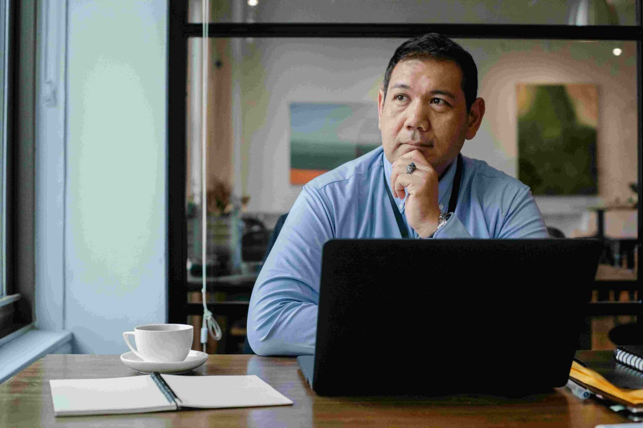 cfo sitting and thinking at desk with laptop